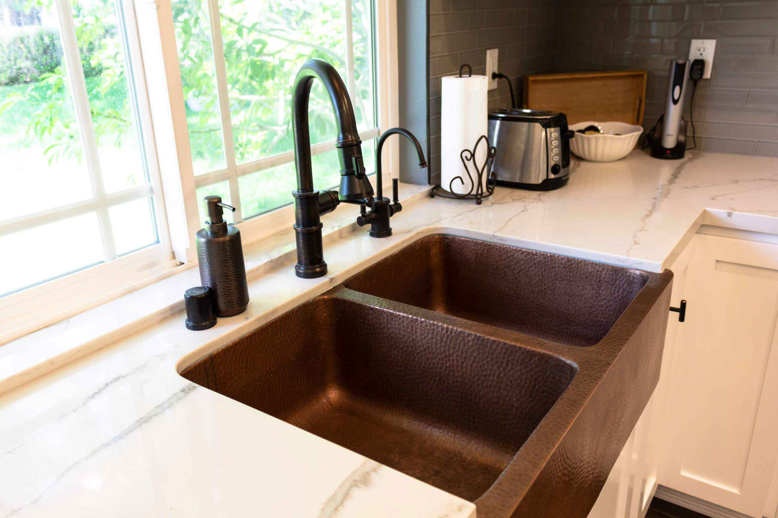 A hammered metal sink basin with bronze faucet, part of a complete home remodel in Porter Ranch, California by Los Angeles design-build firm A-List Builders.