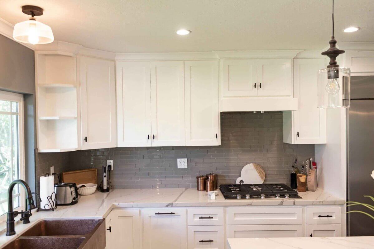 Antique lighting fixtures add visual appeal to this kitchen, part of a complete home remodel in Porter Ranch, California by design-build firm A-List Builders.