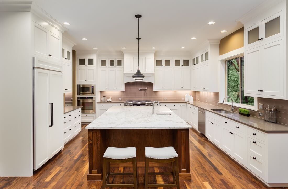 A large island with an additional sink and bar seating, part of a kitchen remodel in Los Angeles, California by design-build firm A-List Builders, serving LA.