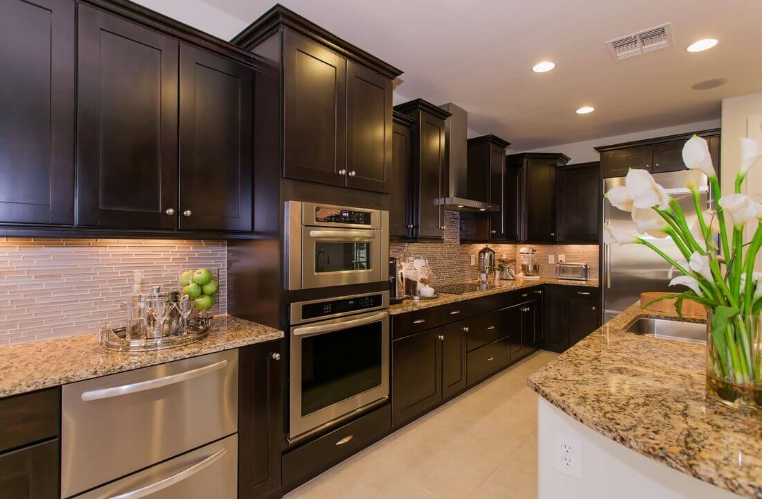 A combination wall oven with beautiful dark cabinets, part of a kitchen remodel in Los Angeles, California by Los Angeles design-build firm A-List Builders.