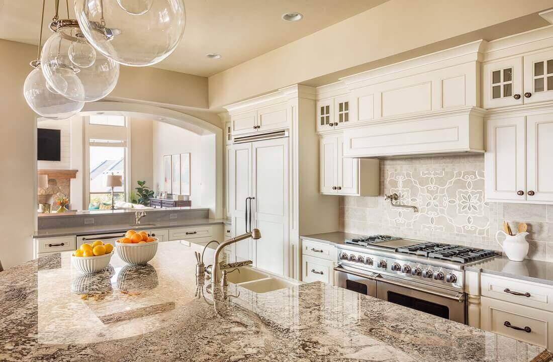 Globe pendant lights over an island, part of a kitchen remodel in Los Angeles, California by design-build firm A-List Builders, which serves the LA area.