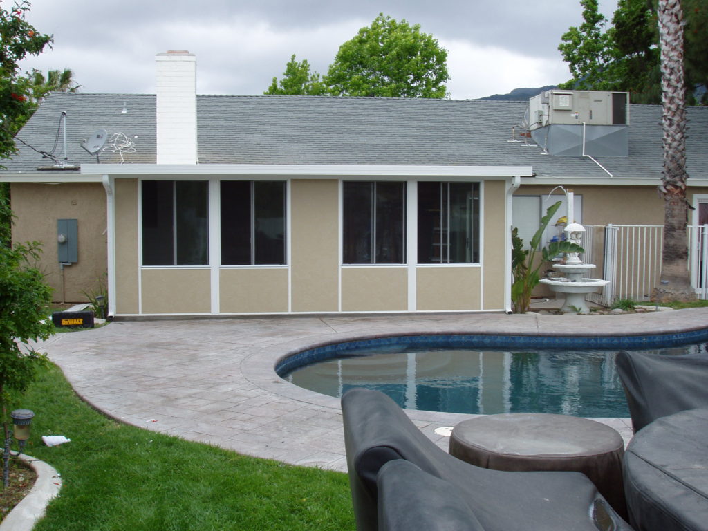 This backyard patio enclosure looks onto a swimming pool, part of a home remodel by design-build firm A-List Builders, serving all of Los Angeles.