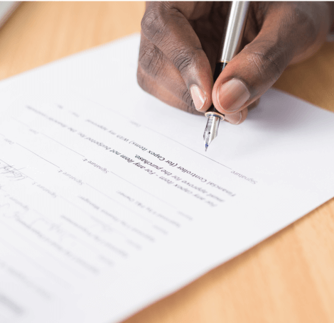 Male hand signing contract papers with pen