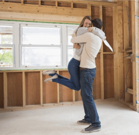 Happy young couple embrace in unfinished home