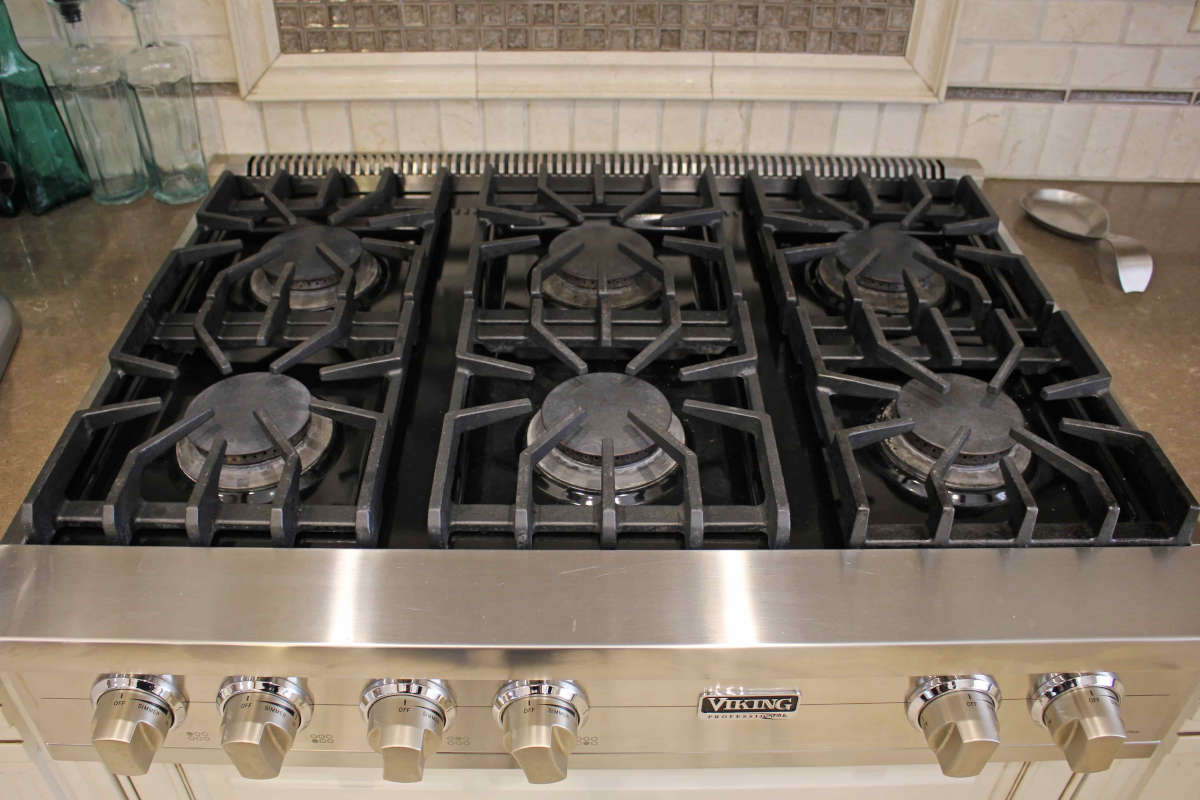 A close up of the gas burners on an upscale new range top, part of a kitchen remodel in Sherman Oaks, CA by Los Angeles design-build firm A-List Builders.