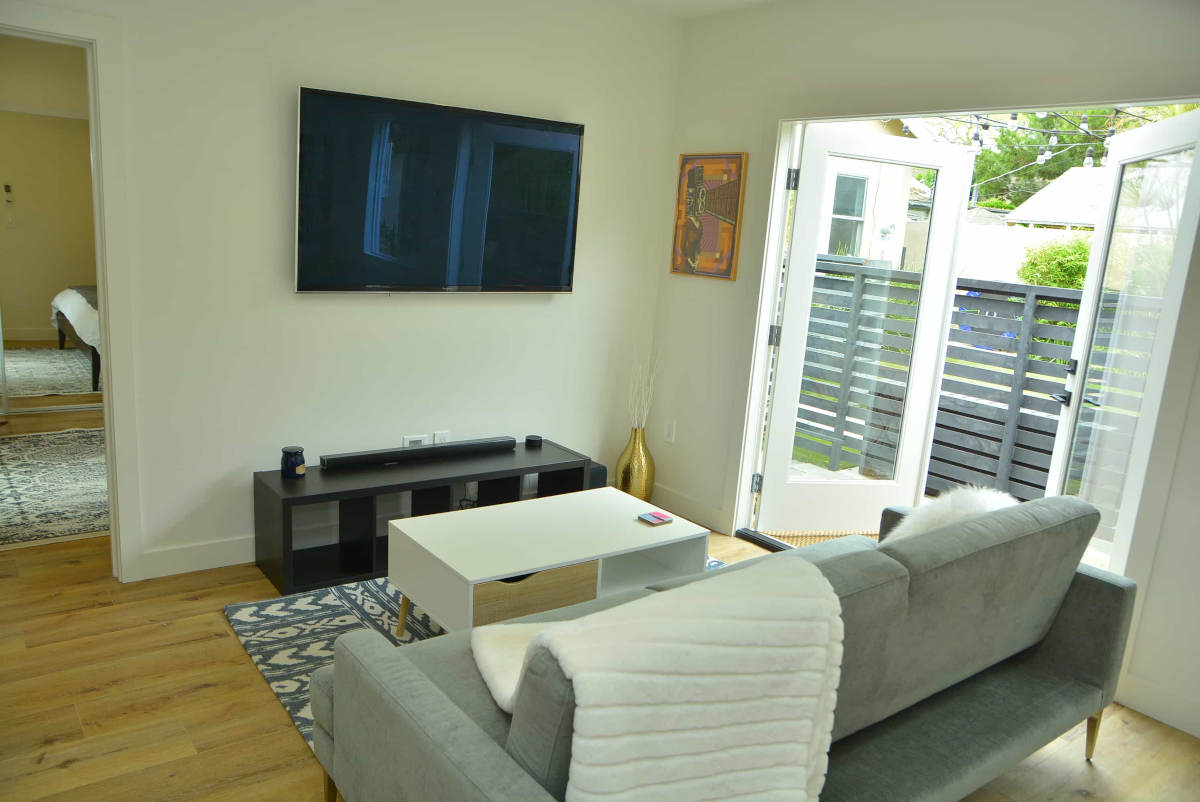 A cozy living room with double doors to the patio at a house in Beverlywood, CA, part of a complete home remodel by LA design-build firm A-List Builders.