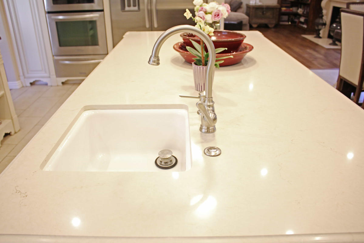 The sink and white counter tops on a kitchen island, part of a home remodel in Sherman Oaks, CA by upscale Los Angeles design-build firm A-List Builders.