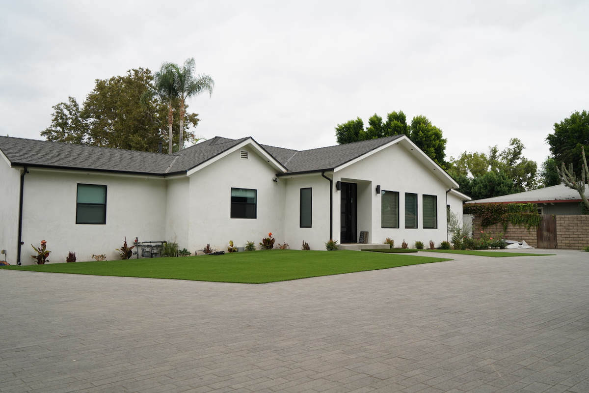 Elegant, understated driveway hardscaping and lawns in the front of a Sherman Oaks, CA home, part of a custom home build by A-List Builders.