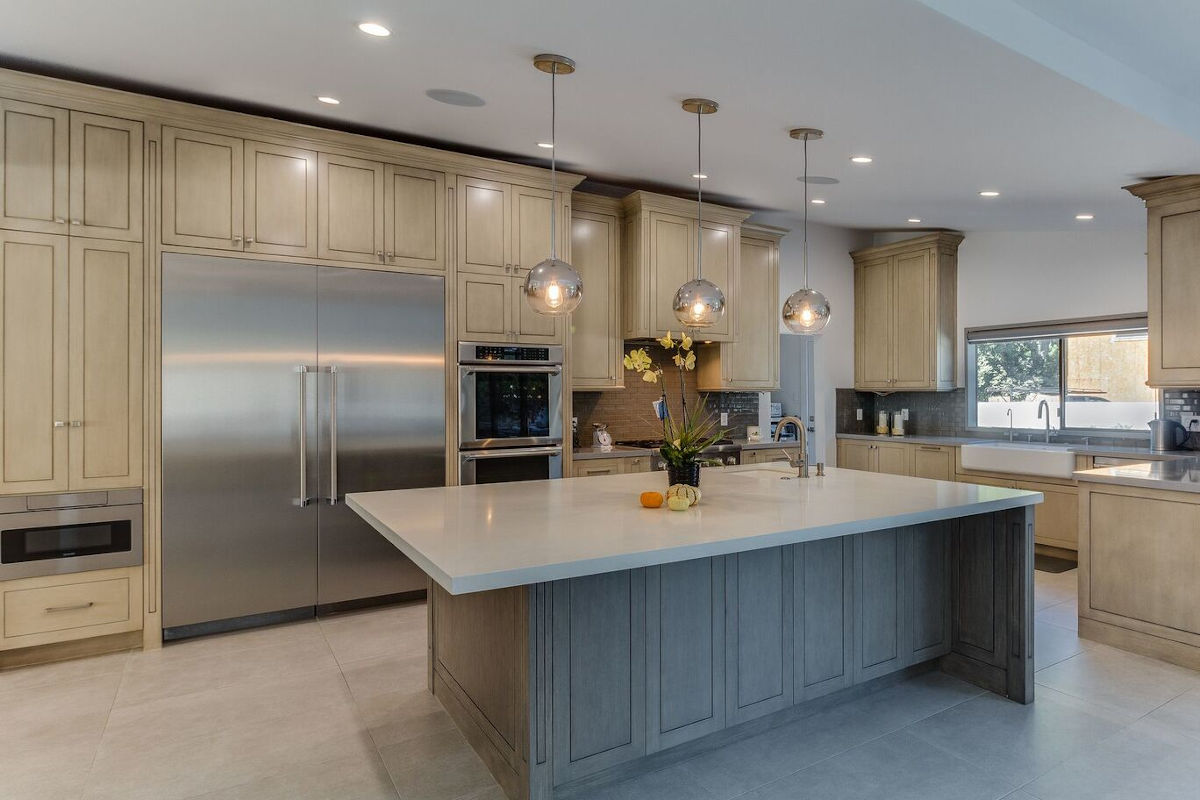 A spacious, light-filled kitchen with a large fridge at a home in Sherman Oaks, CA, part of a home remodel by Los Angeles design-build firm A-List Builders.