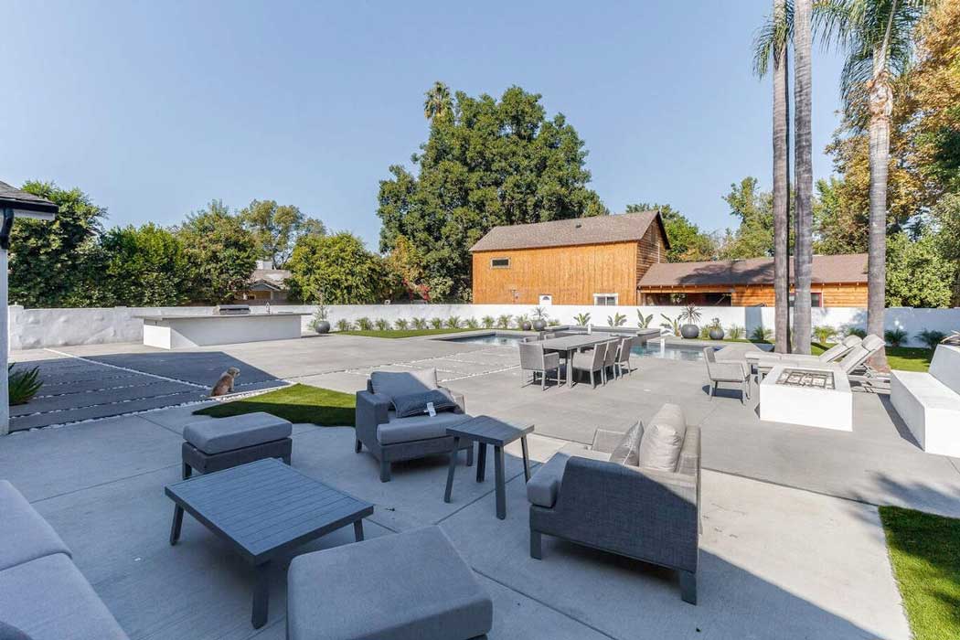 A hardscaped backyard and swimming pool at a home in Sherman Oaks, CA, part of a home remodel by Los Angeles design-build firm A-List Builders.