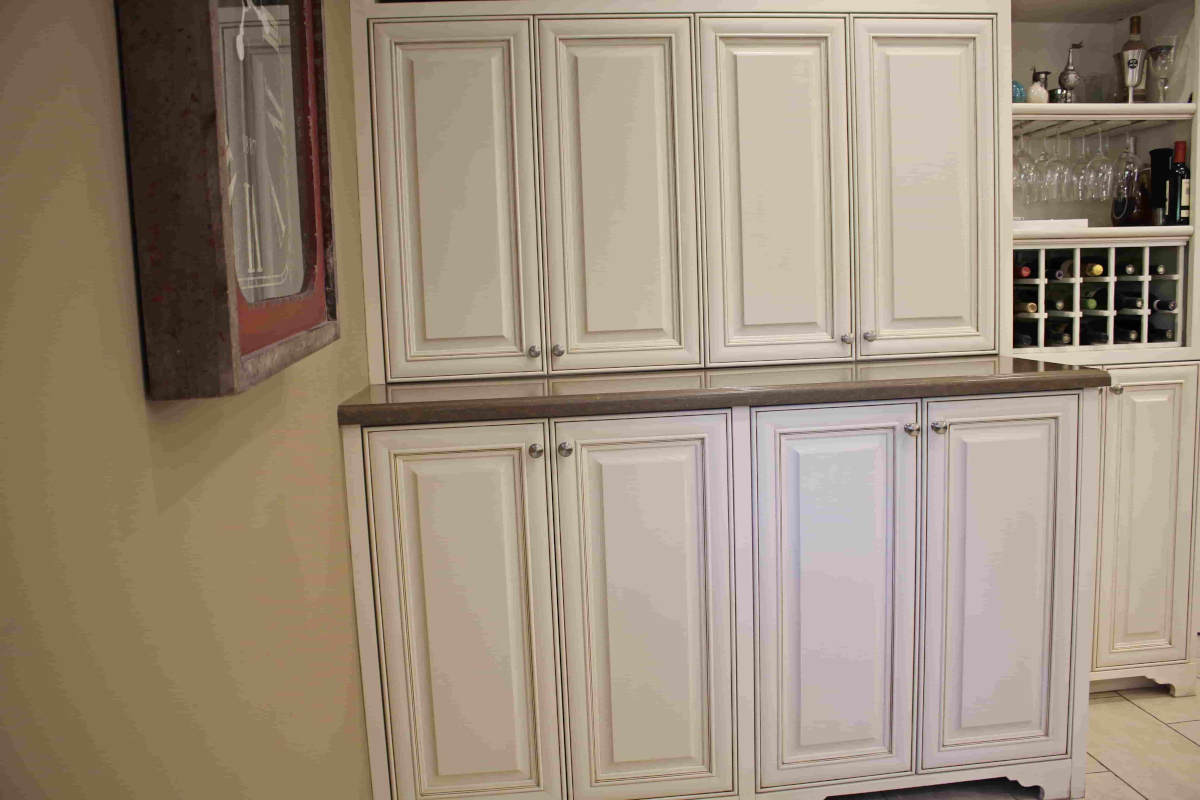 Elegant white cabinetry conceals a laundry space at a home in Sherman Oaks, CA, part of a home remodel by Los Angeles design-build firm A-List Builders.