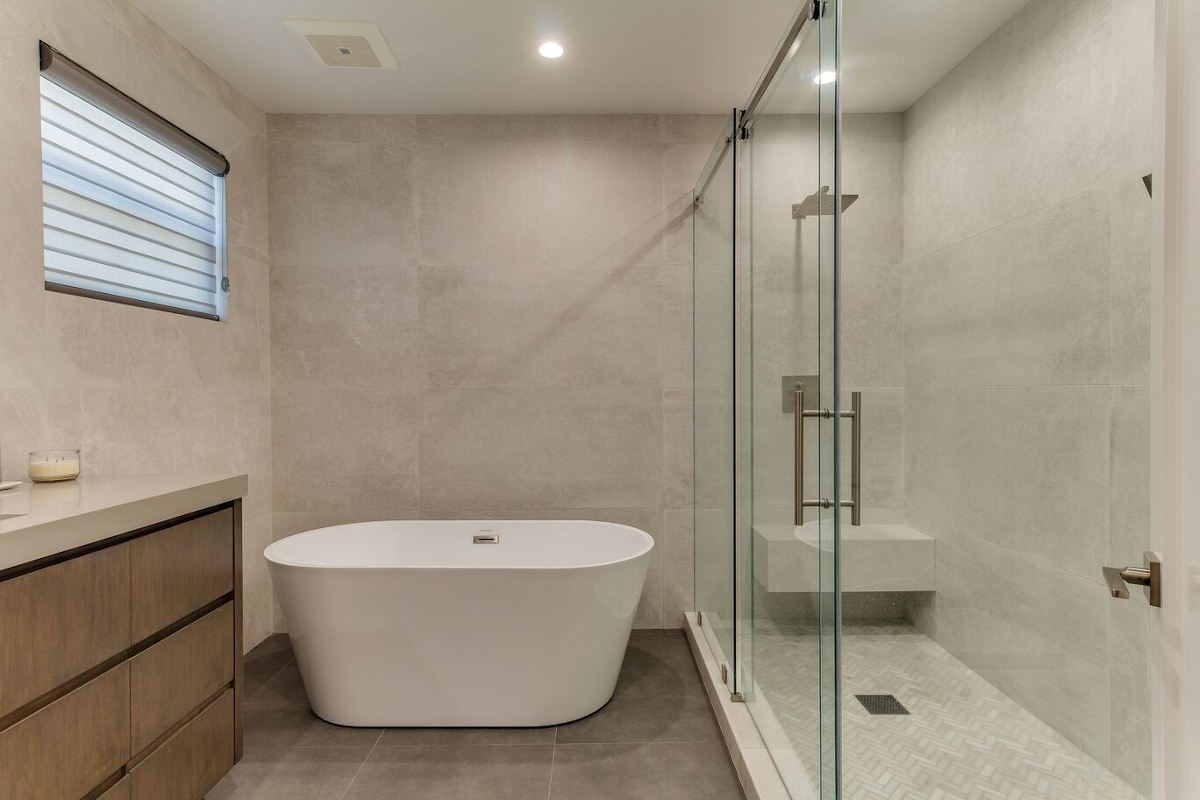 A large walk-in shower and legless freestanding bathtub, part of a home remodel in Sherman Oaks, CA by upscale Los Angeles design-build firm A-List Builders.