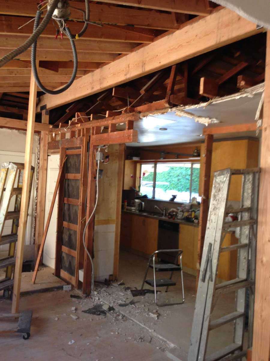 The frame of a living room and kitchen are exposed during construction work on a home in Sherman Oaks, CA by Los Angeles design-build firm A-List Builders.