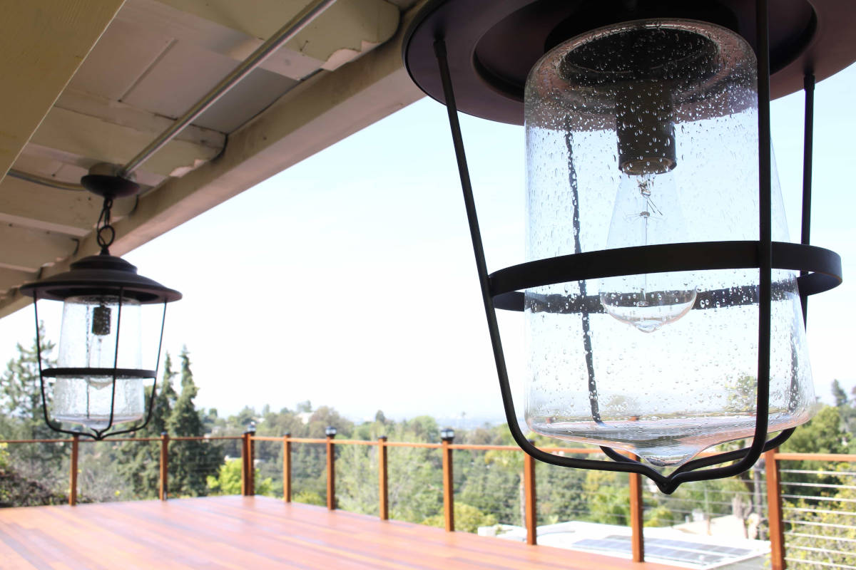 Vintage light fixtures hang under the eaves of a deck at a house in Studio City, CA, part of a home remodel by Los Angeles design-build firm A-List Builders.