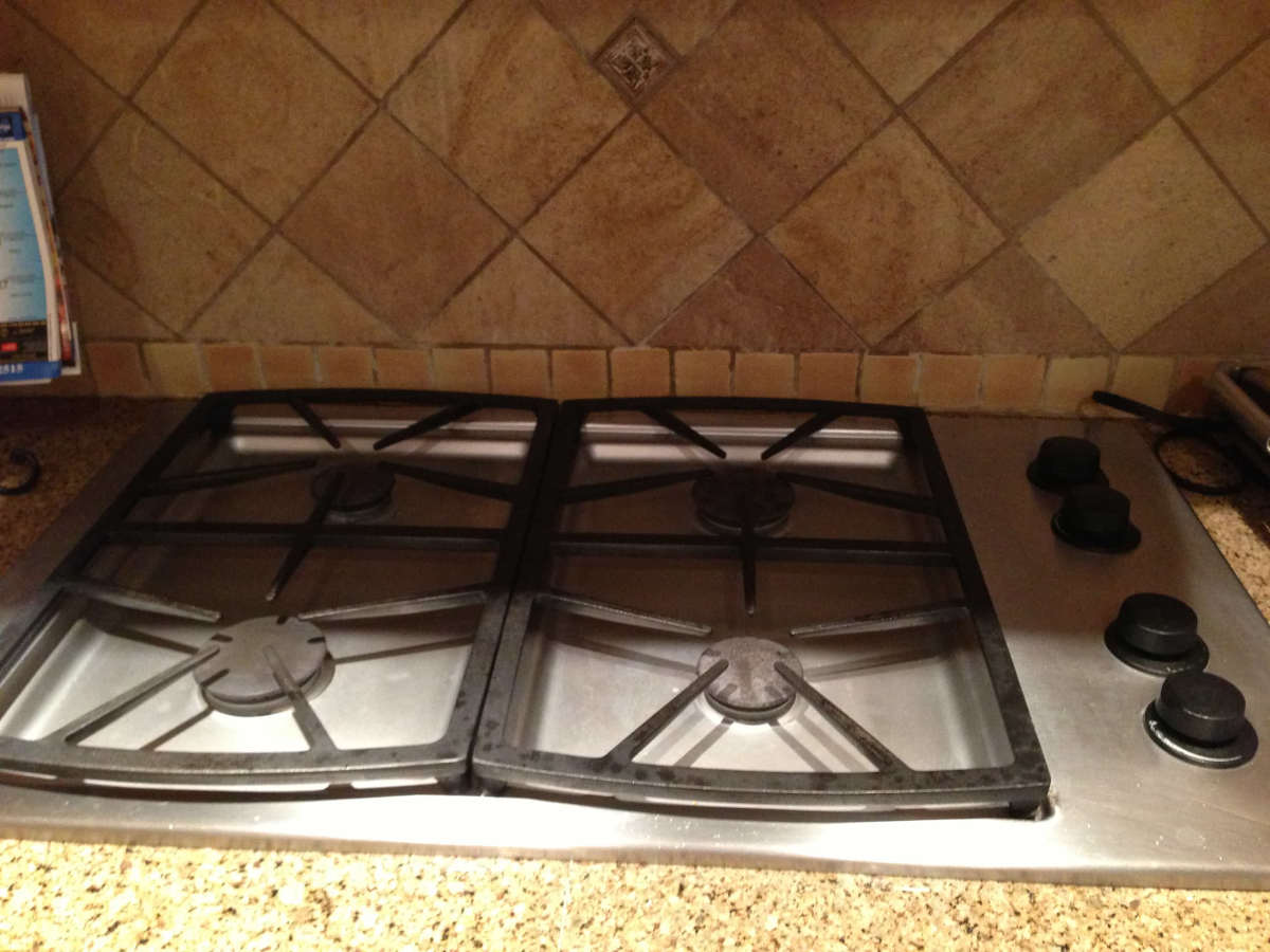 A new range top, polished stone counters, and tile backsplash, part of a home remodel in Studio City, CA by Los Angeles design-build firm A-List Builders.