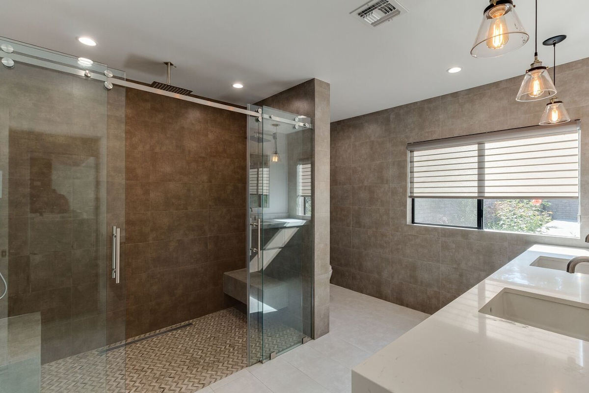 A finished walk-in shower with overhead spigot, part of a home remodel in Sherman Oaks, CA by Los Angeles design-build firm A-List Builders.