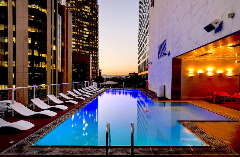 Rooftop pool and lounge chairs overlooking the LA skyline.