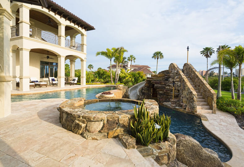 An elaborate backyard landscape remodel with a water feature.