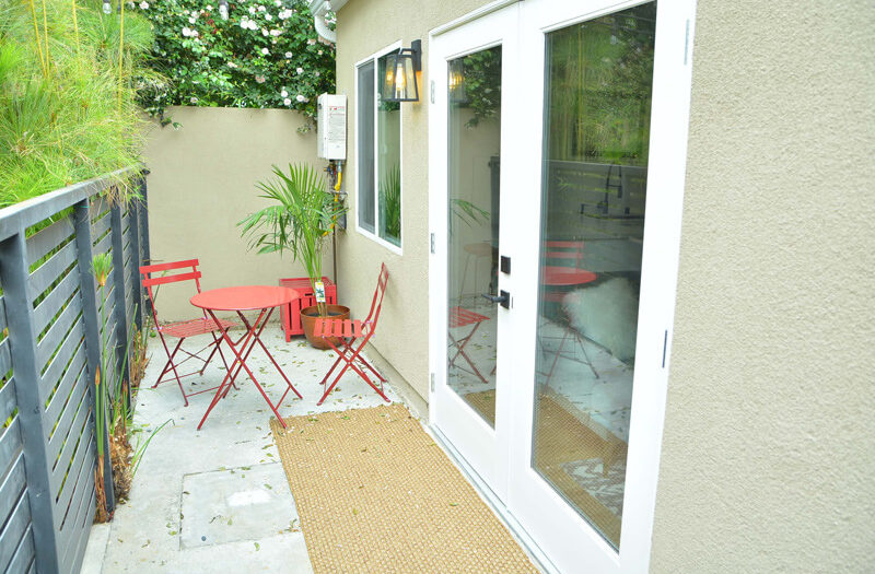 ADU Design idea: guest house with private entry, patio furniture and privacy fence in Beverlywood CA.