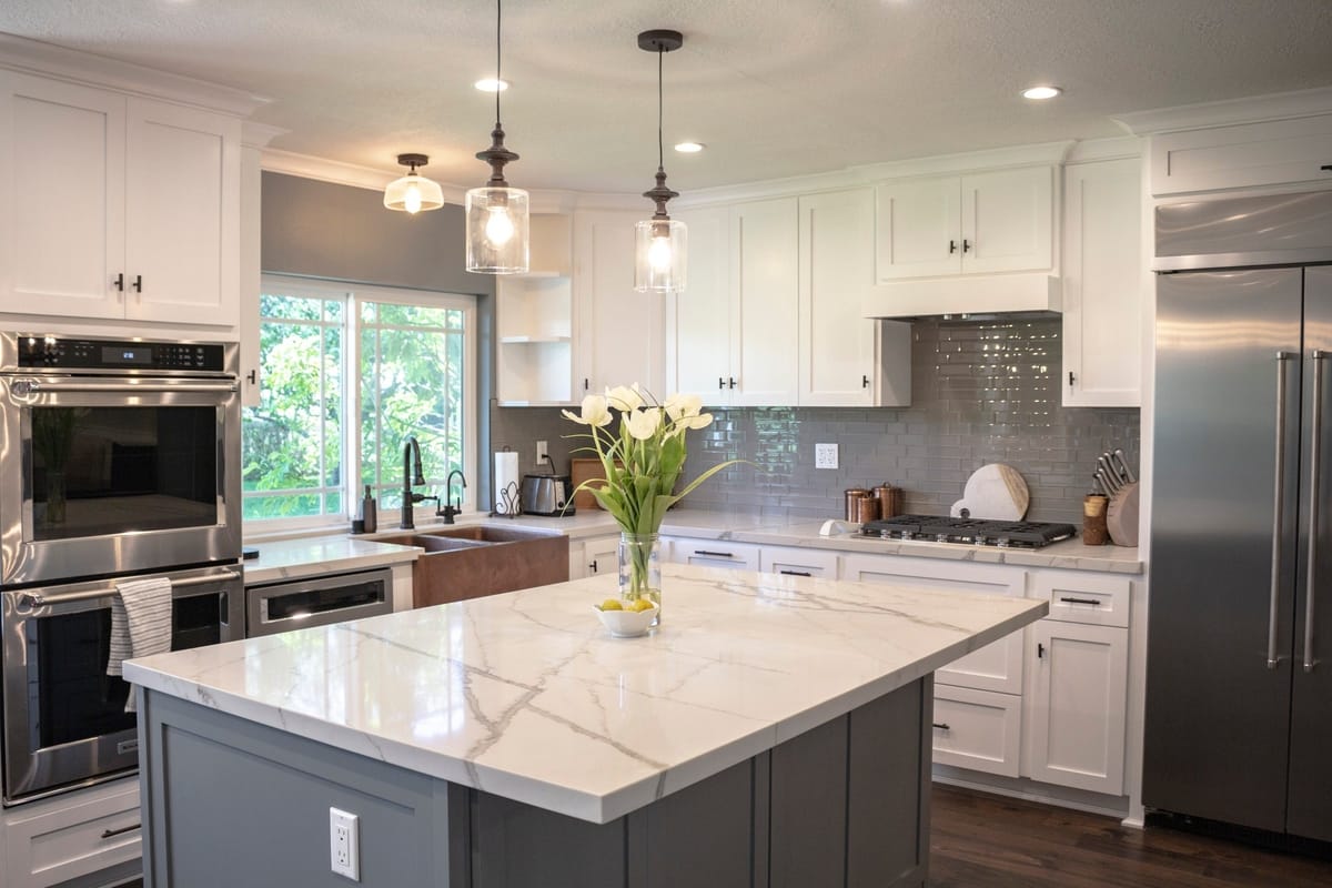 A vase of flowers adds a note of color to this white and gray kitchen decor, part of a complete home remodel in Porter Ranch, California by A-List Builders.