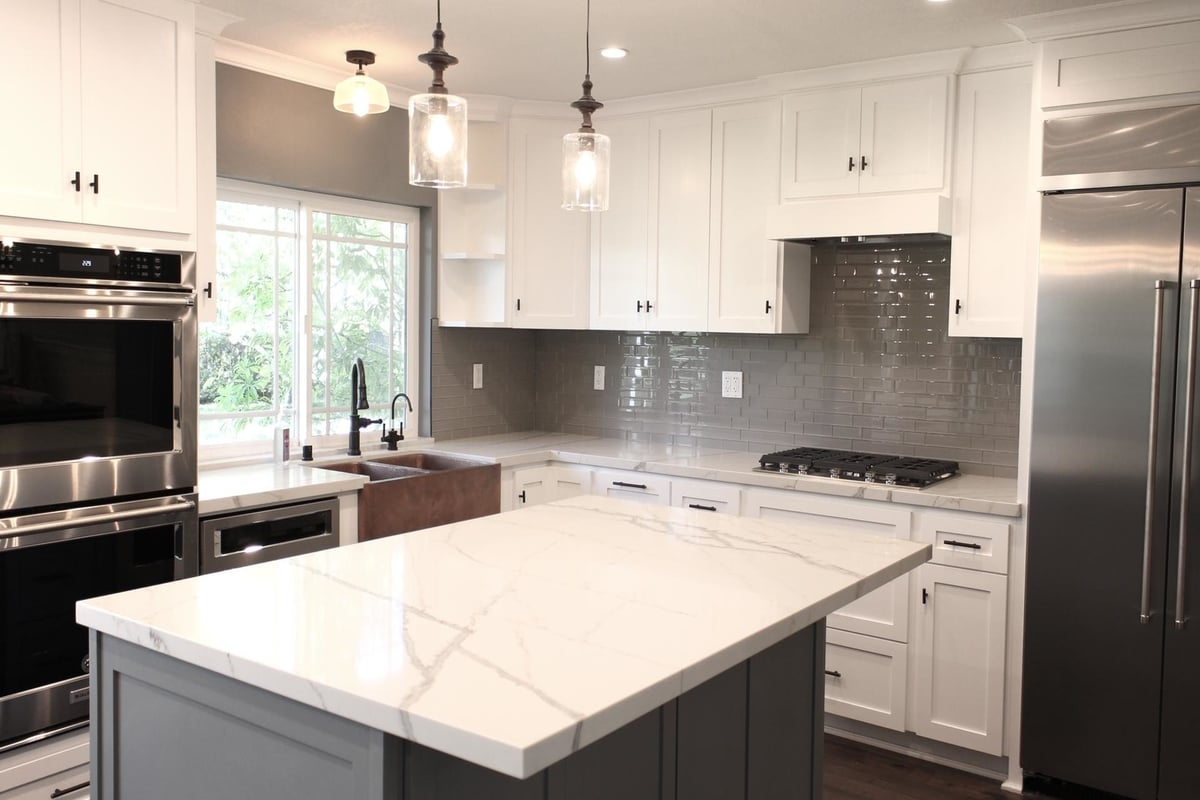 The white marble counter on this kitchen island provides a central focal point, part of a complete home remodel in Porter Ranch, California by A-List Builders.