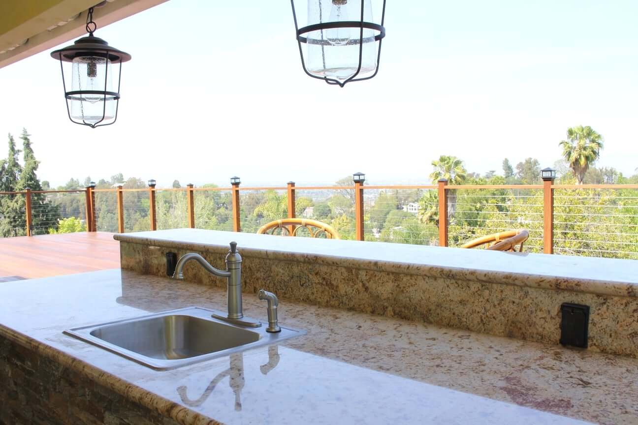 A wet bar with sink and stone counter tops on a deck at a home in Studio City, CA, part of a deck remodel by Los Angeles design-build firm A-List Builders.
