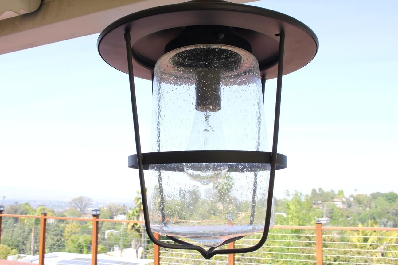 An antique light fixture hangs on a covered deck, part of a home remodel at a property in Studio City, CA by Los Angeles design-build firm A-List Builders.