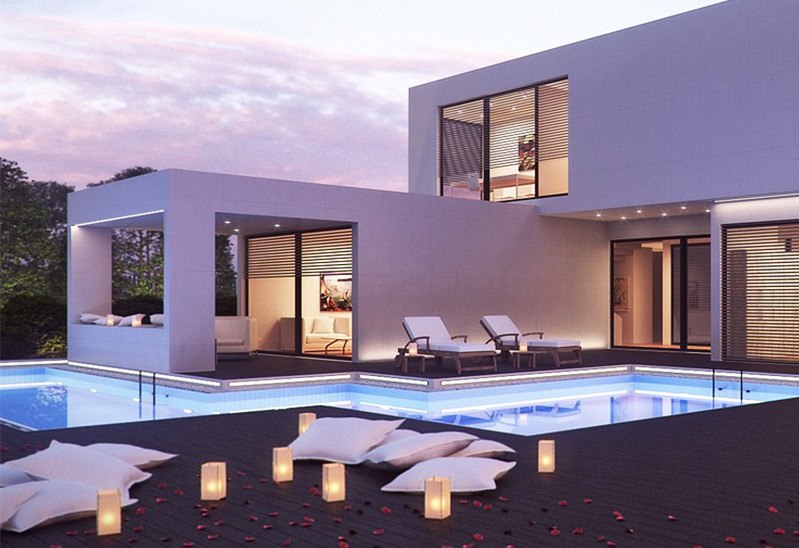 Modern home exterior & pool at dusk with pillows & luminaries