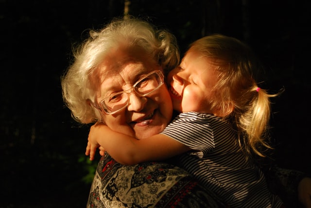 Grandmother holding her granddaughter and smiling.