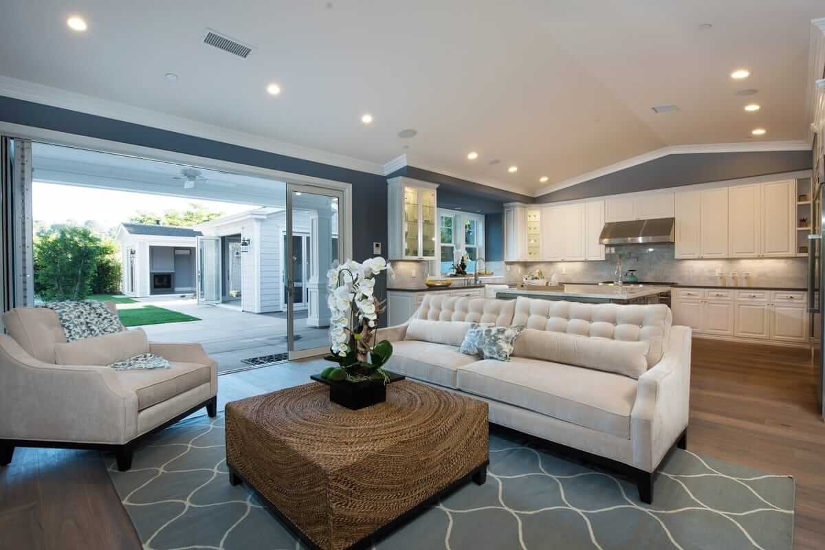 A blue and white living room with a sliding glass wall, part of a home remodel by Los Angeles design-build firm A-List Builders.